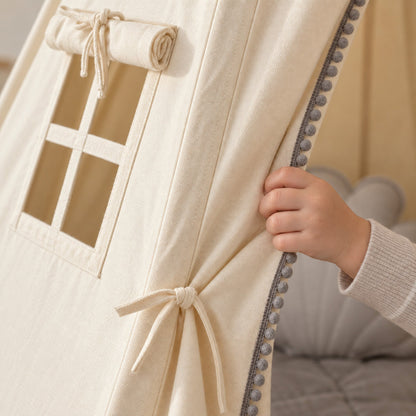 Close-up of the grey pompom trim on cream cotton canvas